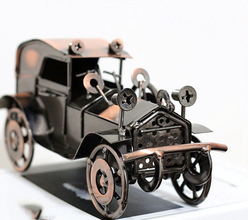 Metallic model of an old-fashioned car on a white background