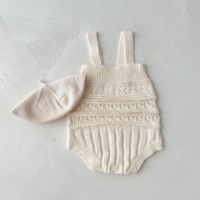 Knitted baby romper with lace details and matching hat on a light gray background