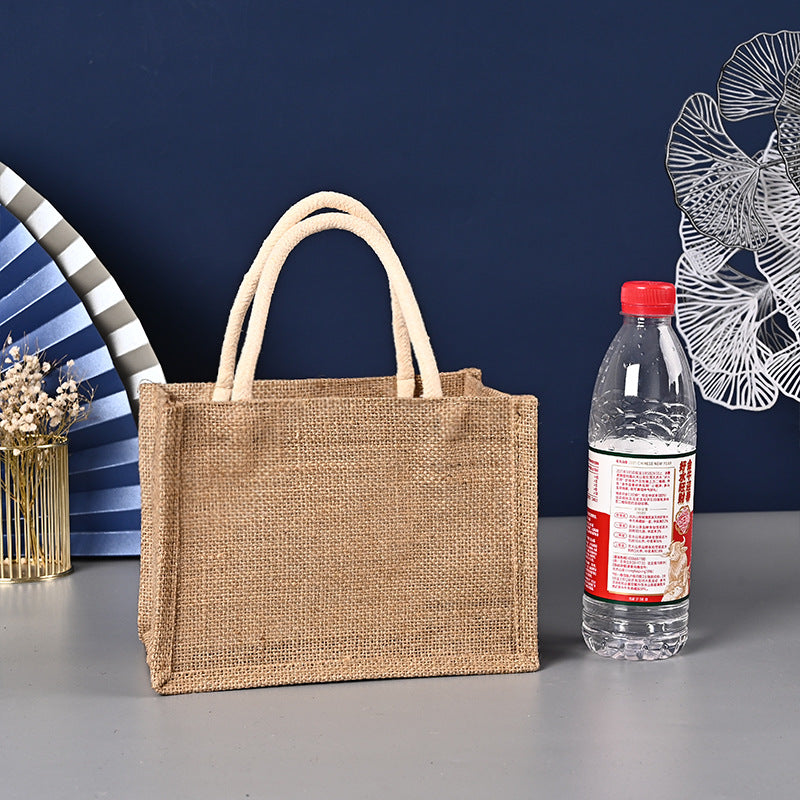 Jute bag and a bottle of water on a gray surface with a dark blue background