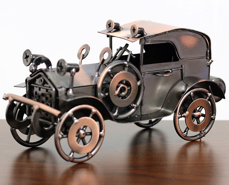 Metallic model of an old-fashioned car on a reflective surface