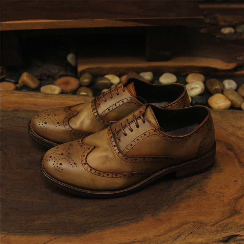 Pair of brown leather shoes on a wooden surface with a rustic background.