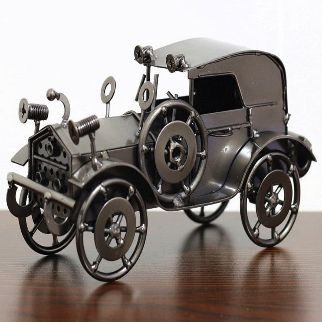 Metallic model of an old-fashioned car on a wooden surface