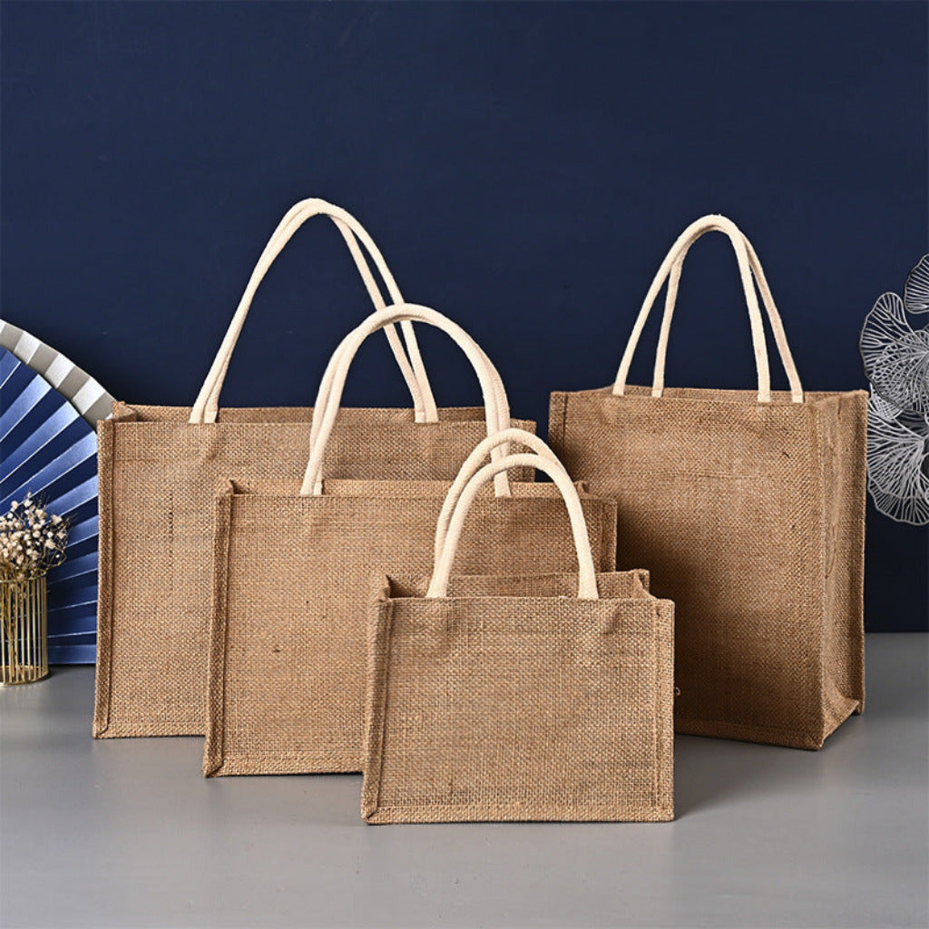 Three brown jute bags of different sizes on a gray surface with a blue background