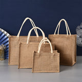 Three brown jute bags of different sizes on a gray surface with a blue background