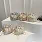 Set of decorative bags with pearl embellishments on a white surface.