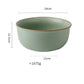 Green ceramic bowl with measurements on a white background