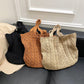 Three knitted tote bags in black, brown, and beige on a dark surface.