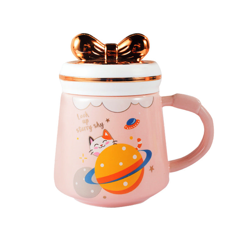 Pink mug with a cat and planet design on a white background