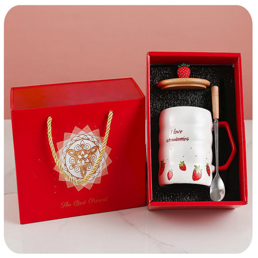 Gift set with a mug, spoon, and strawberry decoration in a red box.