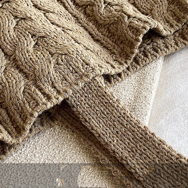Close-up of a textured beige blanket on a neutral background