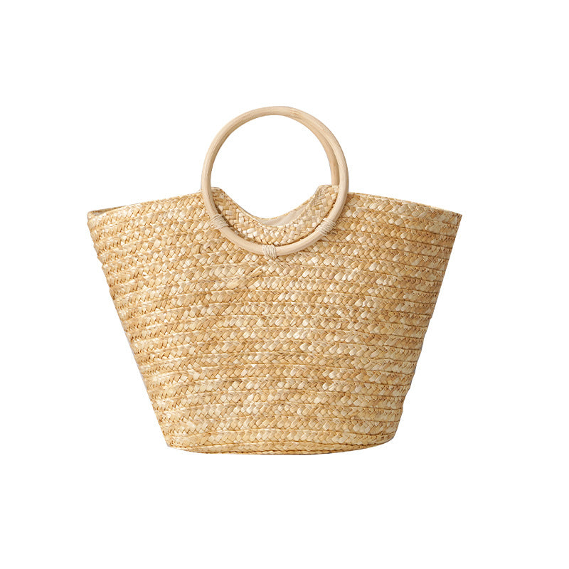 Woven straw bag with circular handles on a white background