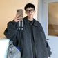Person wearing a textured gray coat taking a mirror selfie.