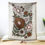 Floral patterned throw blanket with tassels on a white background