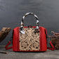 Red handbag with intricate leather design on a dark background