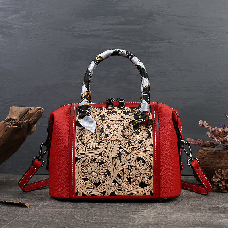 Red handbag with intricate leather design on a dark background