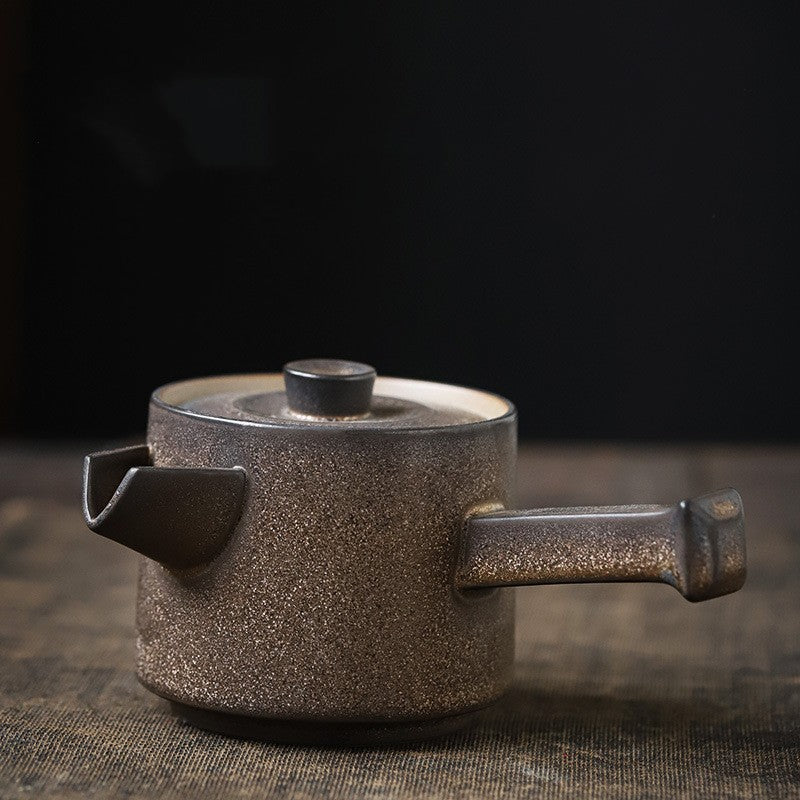 Brown speckled ceramic teapot on a dark background