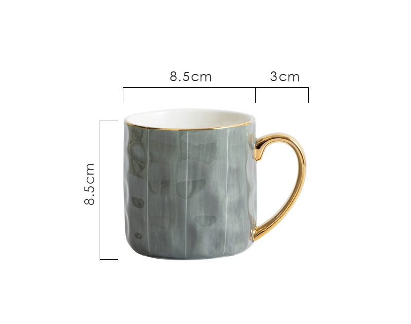 Gray marbled mug with gold handle and measurements on a white background