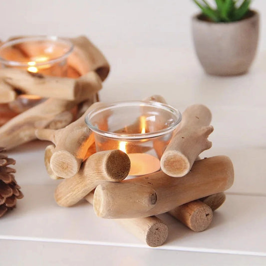 Candle holder made of wooden logs with a small candle inside on a white surface.