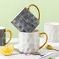Marble-textured mugs with gold handles on a light green background