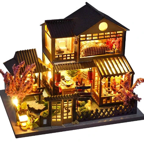 Light-up model of a house with interior details on a white background