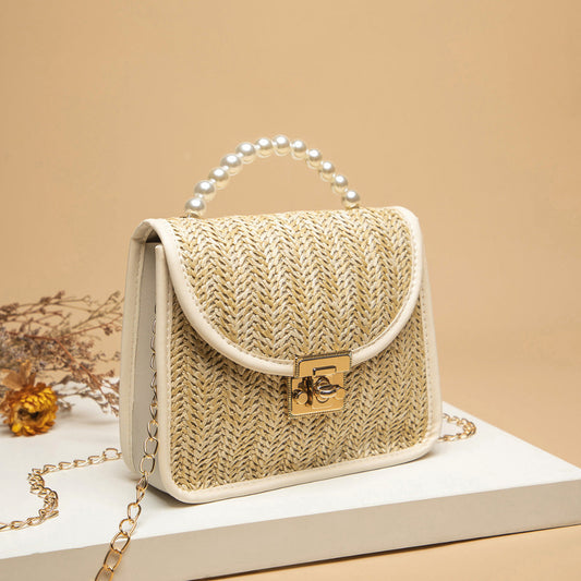 Woven handbag with pearl handle on a beige background