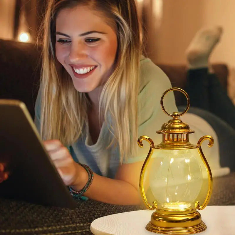 Woman using a laptop with a decorative lamp on a table in a cozy indoor setting