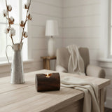 Wooden candle holder with a lit candle on a wooden surface