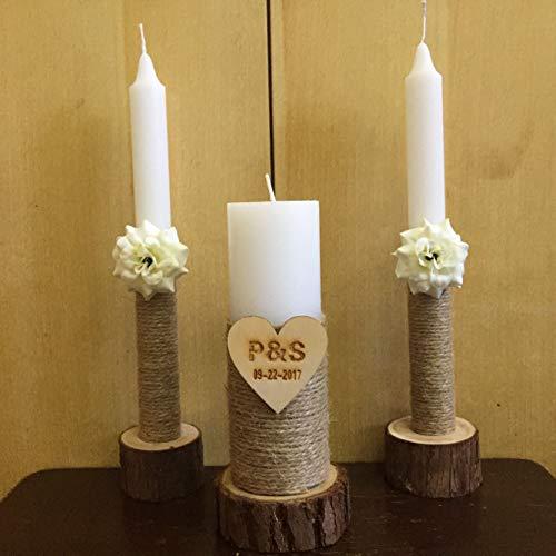 Three candles on wooden stands with floral decorations and a heart-shaped plaque against a beige background.